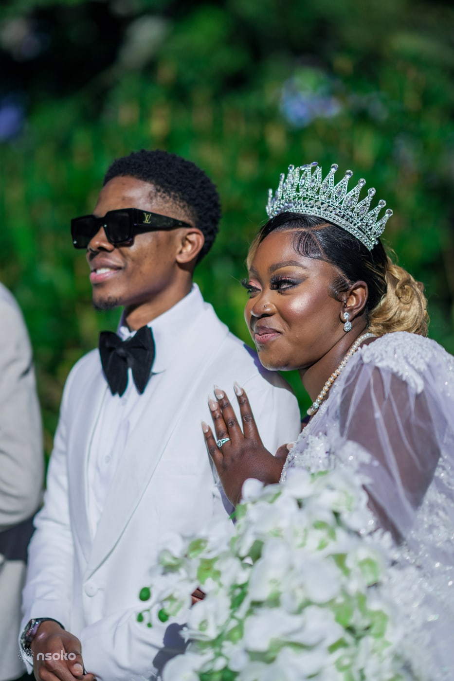 Bride and groom close together, bride wearing a tiara and pearls, photographed by Picha Media
