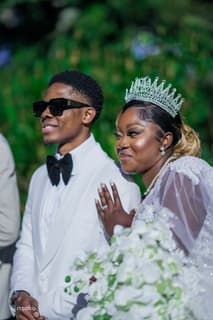 Bride and groom close together, bride wearing a tiara and pearls, photographed by Picha Media